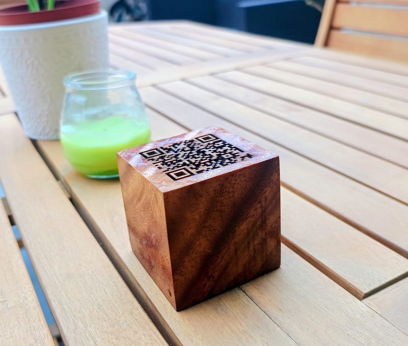Engraved QR code on a wooden block on a café table